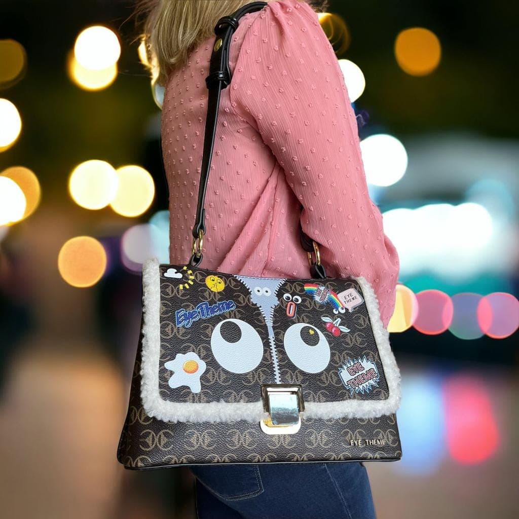 A patch bag worn over the shoulder against city lights at night